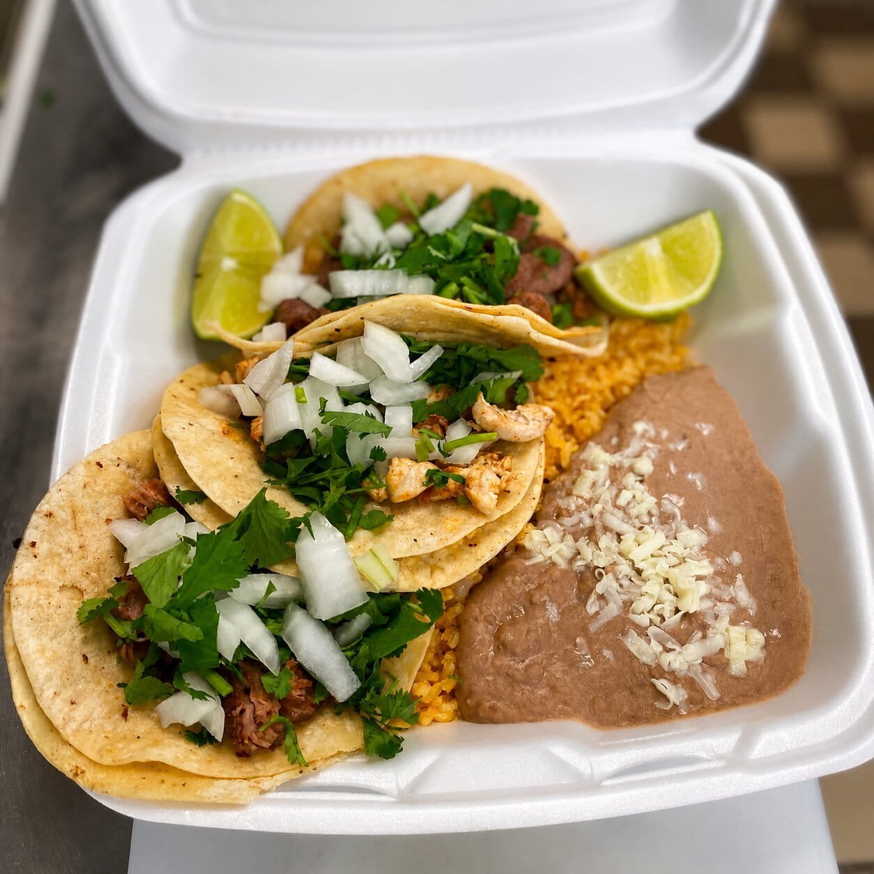 Takeout Mexican street tacos served with rice and refried beans from El Charro Mexican Restaurant